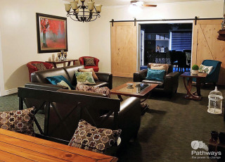 A mental health care center providing drug addiction treatment features a living room with a table and chairs.