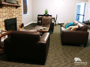 A mental health care center in Utah offering drug rehab services, featuring a living room with couches and a fireplace.