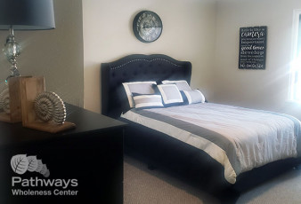 A bedroom with a bed suitable for mental health care patients or those undergoing drug addiction treatment.