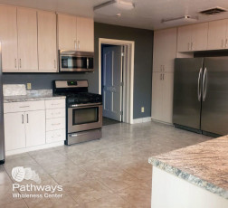 A kitchen with stainless steel appliances and granite counter tops in a drug rehab center.