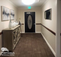 A drug rehab center hallway designed with a black door and brown carpet for addiction treatment in Utah.