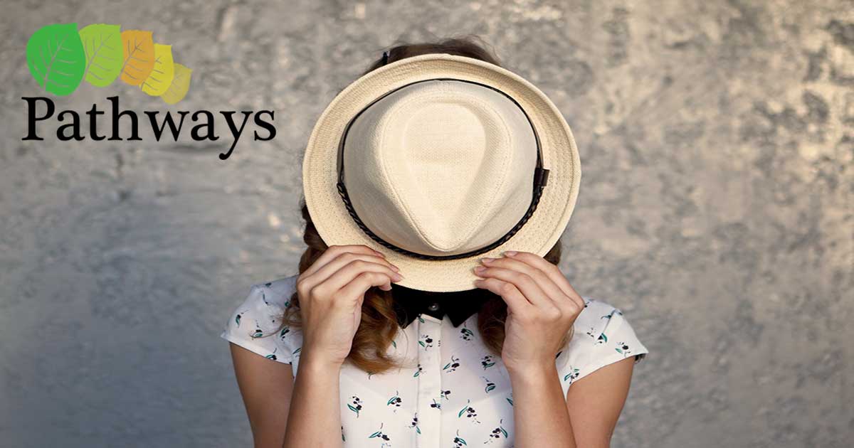 Girl covering face with a hat - 7 Struggles Introverts Have in the Summer