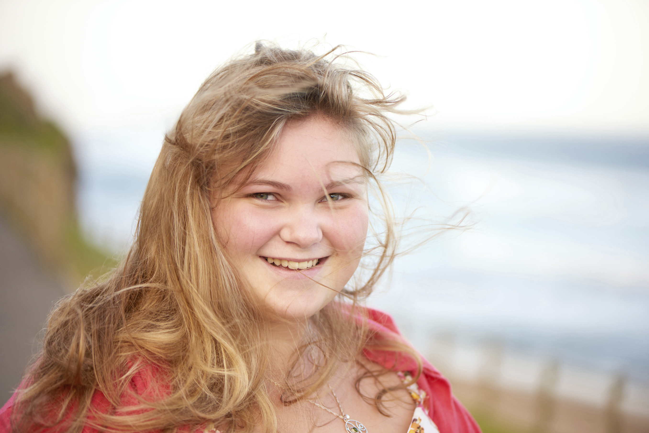 Happy overweight teenager smiling with messy hair